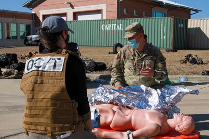 Alexandra Broussard, an Army Interagency Training Education Center observer controller, evaluates Cpl. Robert Lynch, 581st Medical Company Area Support medic, during the Urban Search and Rescue lane at the San Antonio Fire Academy Nov. 5.
