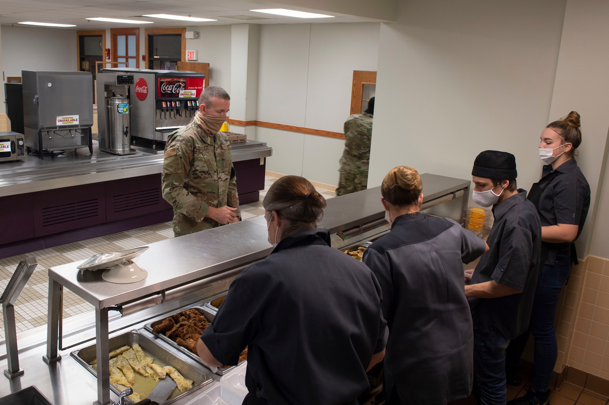 Staff members from the Grissom dining facility serve food during the November unit training facility. Along with social distancing, face coverings, and only allowing carry out during the drill, the dining facility also serves from one line instead of two, ensuring there is a constant flow of traffic and individuals can remain socially distanced. (U.S. Air Force Photo by Tech Sgt. Jami Lancette)