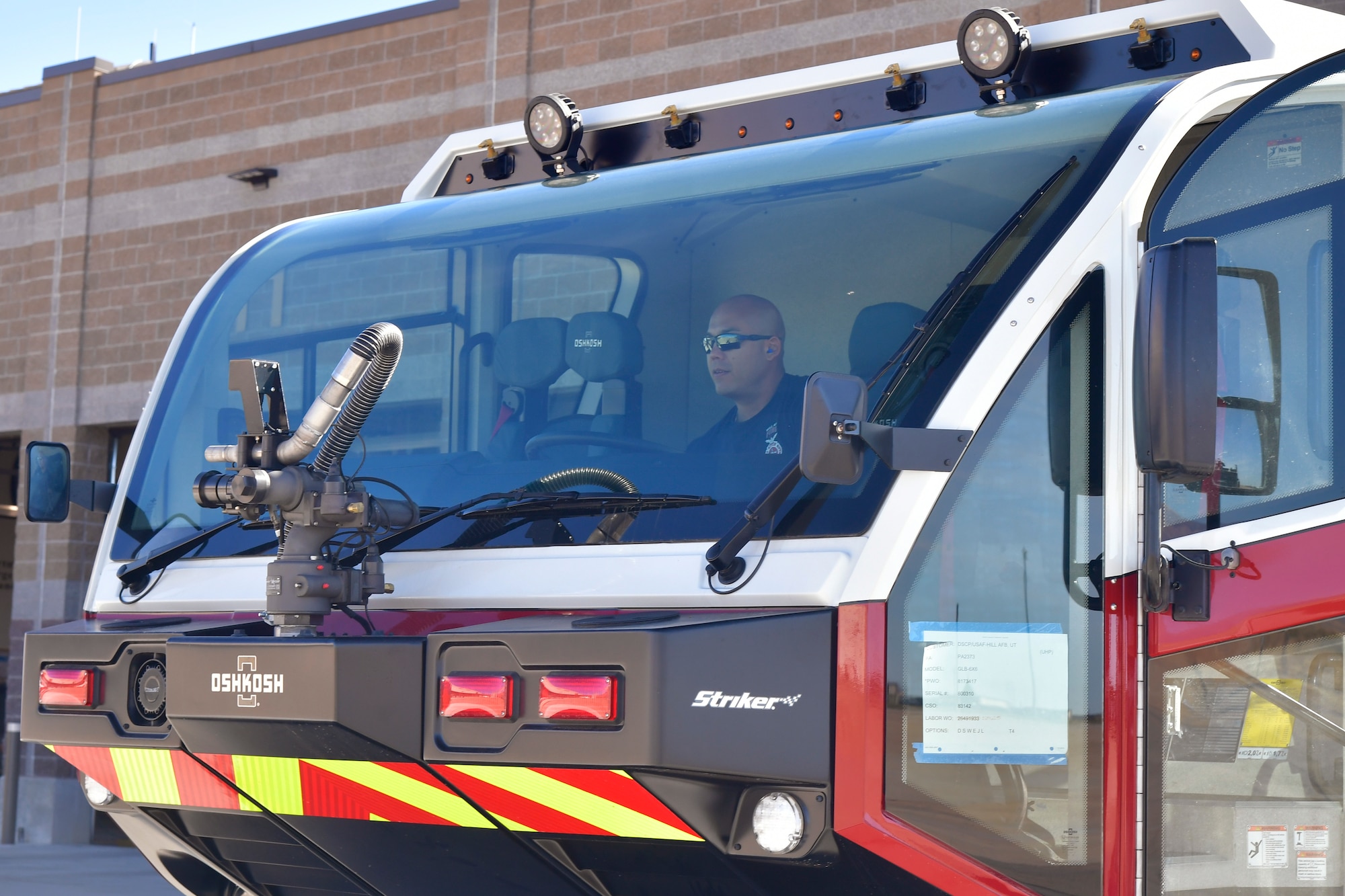A firefighter sits in the cab of a new crash/fire response vehicle.