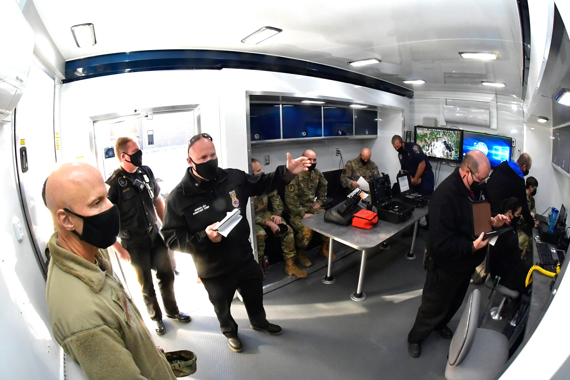 Fire fighters and others inside the MEOC trailer.