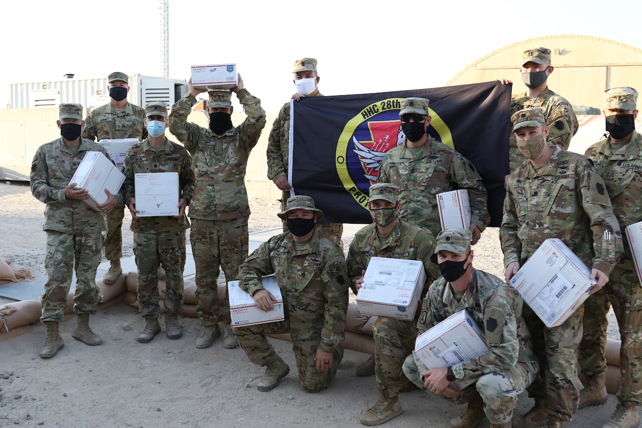 Soldiers pose with care packages.