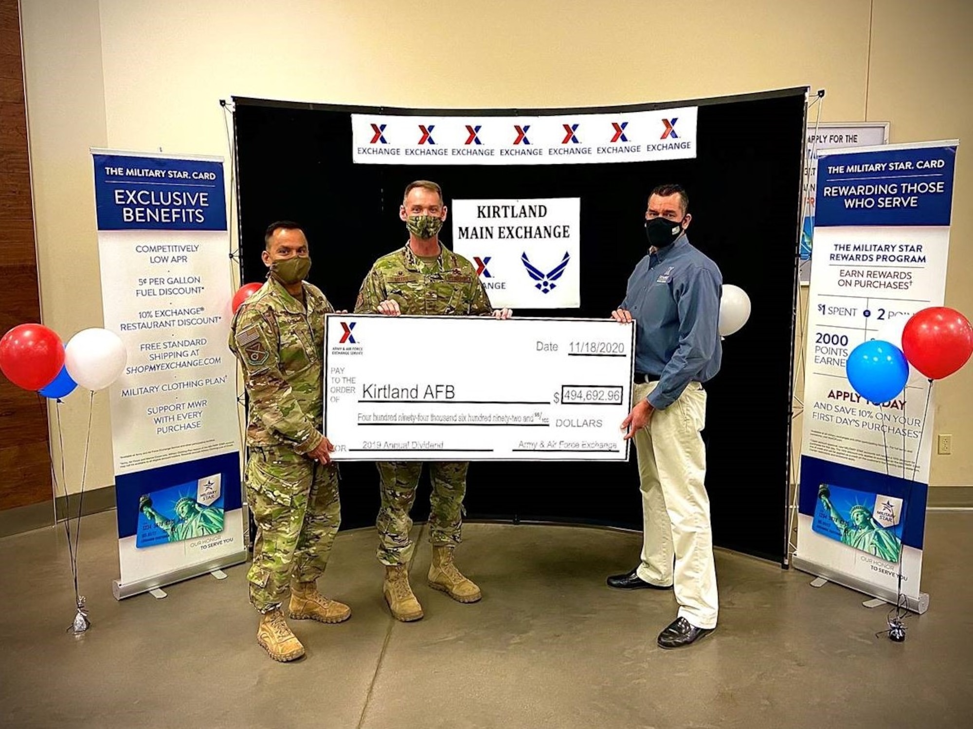 three men holding a large check