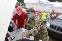 Spc. Josie Staples, 690th Chemical Biological Radiological Nuclear (CBRN) Company from Mobile, Ala., hands out Meals, Ready to Eat to a local citizen affected by Hurricane Sally in Fairhope, Ala. on September 19, 2020. (Alabama Army National Guard Photo by Sgt. Eric Roberts)