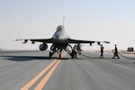 Airmen assigned to the 379th Expeditionary Maintenance Group at Al Udeid Air Base, Qatar, hook a fuel hose to a U.S. Air Force F-16 Fighting Falcon assigned to the 77th Fighter Squadron from Prince Sultan Air Base, Kingdom of Saudi Arabia, on the flight line of AUAB on Nov. 10, 2020. The hot-pit training qualified AUAB Airmen assigned to the 379th Expeditionary Maintenance Group and the 379th Expeditionary Logistics Readiness Squadron to support 24-hour hot refueling operations on multiple aircraft that rotate through the base. Hot-pit refueling allows aircrew to land and keep their engines running while they refuel, before taking off to continue the next leg of their respective missions. (U.S. Air Force photo by Staff Sgt. Kayla White)