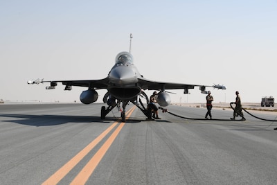 Airmen assigned to the 379th Expeditionary Maintenance Group at Al Udeid Air Base, Qatar, hook a fuel hose to a U.S. Air Force F-16 Fighting Falcon assigned to the 77th Fighter Squadron from Prince Sultan Air Base, Kingdom of Saudi Arabia, on the flight line of AUAB on Nov. 10, 2020. The hot-pit training qualified AUAB Airmen assigned to the 379th Expeditionary Maintenance Group and the 379th Expeditionary Logistics Readiness Squadron to support 24-hour hot refueling operations on multiple aircraft that rotate through the base. Hot-pit refueling allows aircrew to land and keep their engines running while they refuel, before taking off to continue the next leg of their respective missions. (U.S. Air Force photo by Staff Sgt. Kayla White)