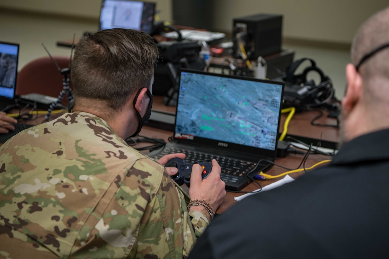 A service member looks at a laptop screen.