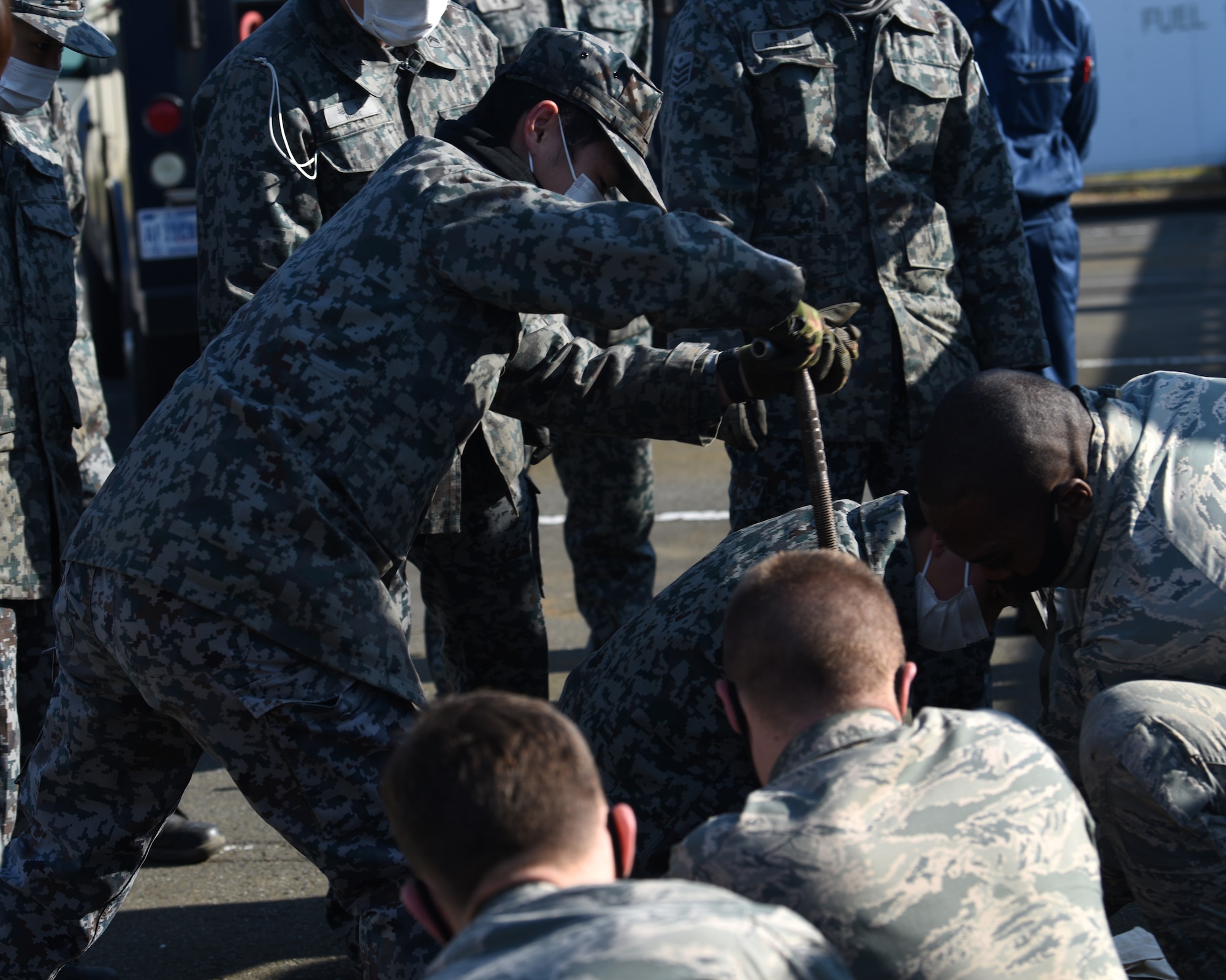 Individuals in uniform perform training outside