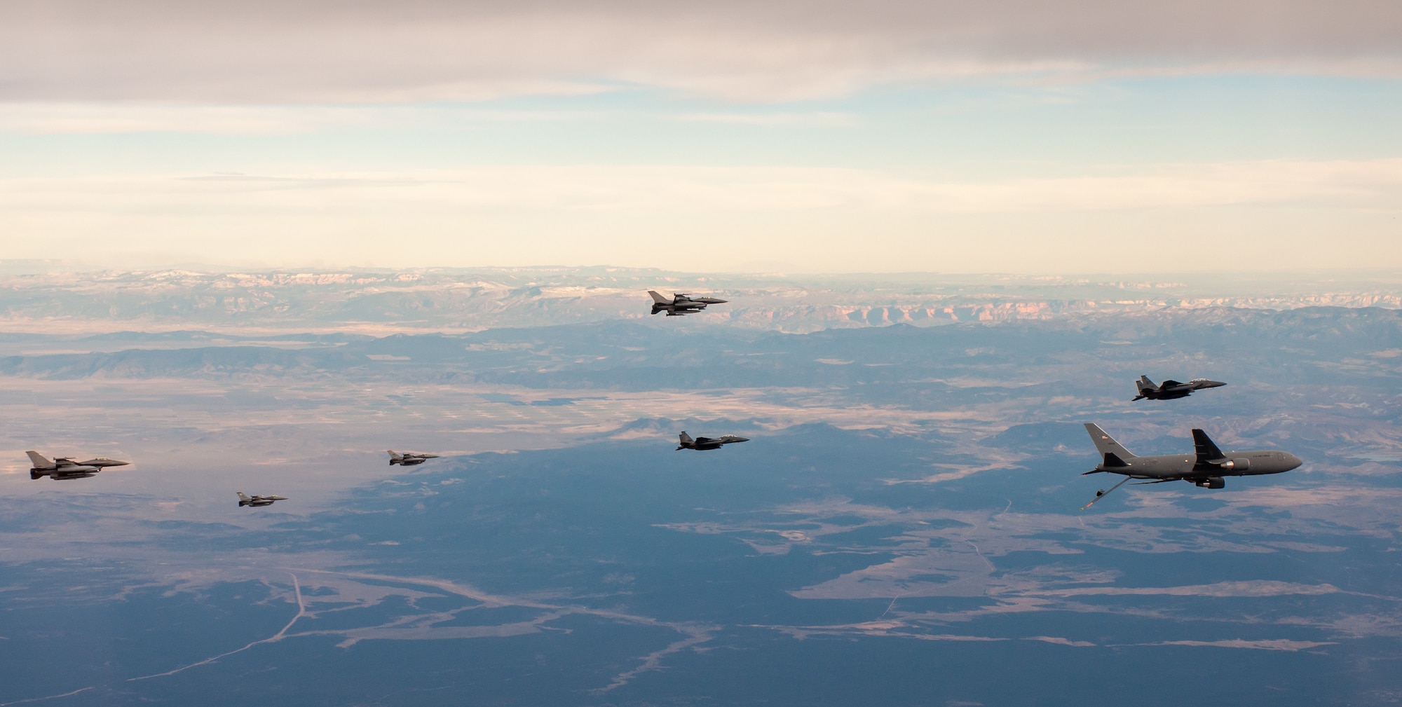 F-15Es and F-16s fly alongside a KC-46