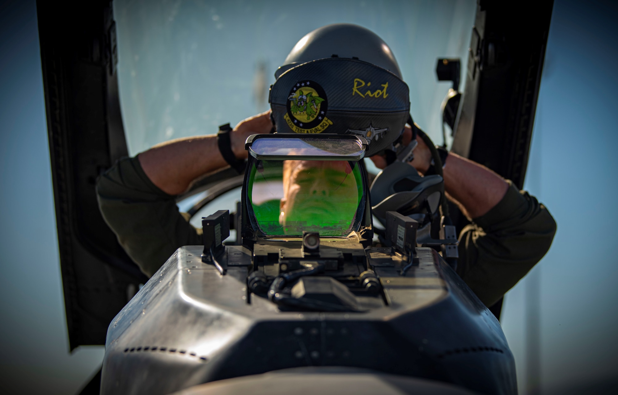 a pilot puts on his helmet