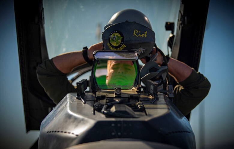 a pilot puts on his helmet