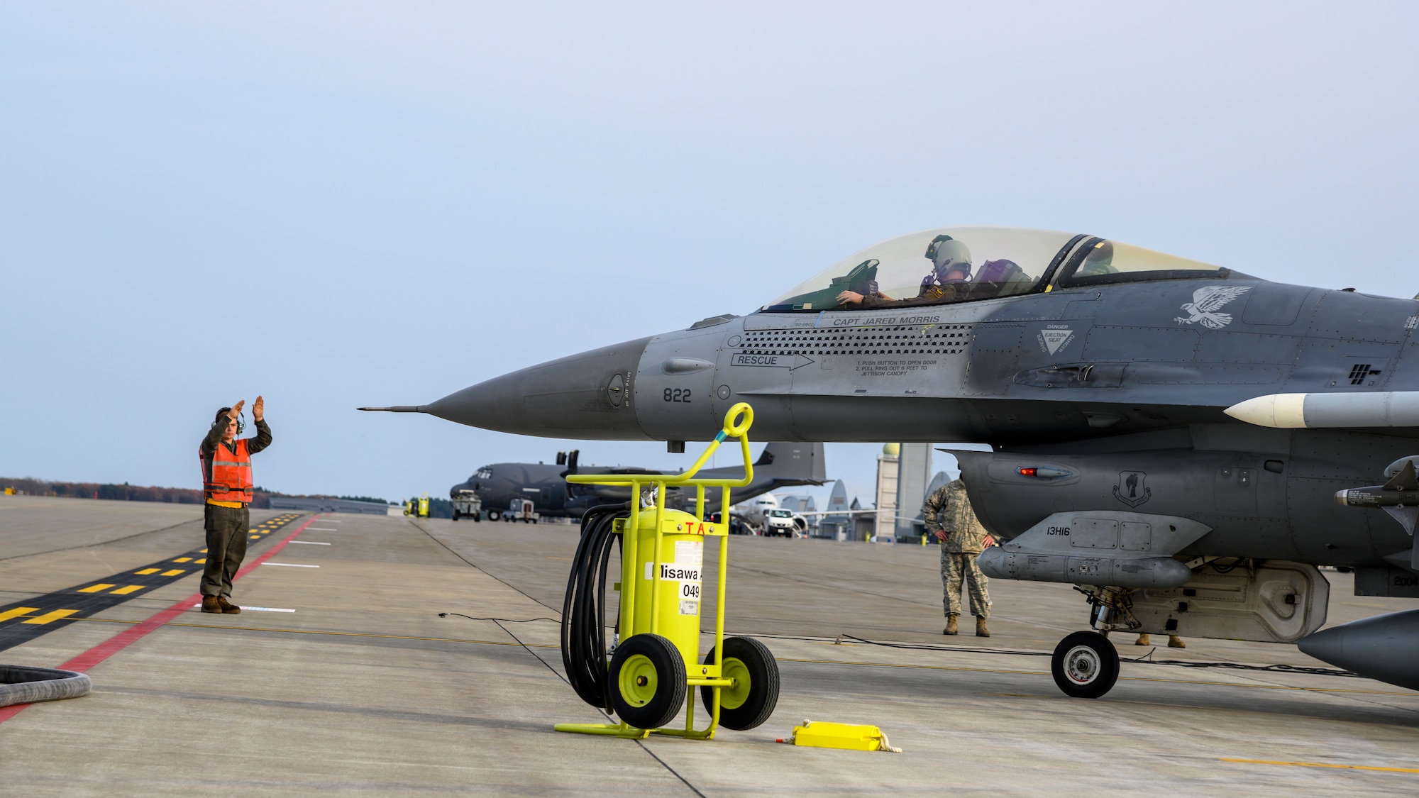 A U.S. Airman with the 35th Air Maintenance Squadron directs an F-16 Fighting Falcon during a forward area refueling point training (FARP) exercise at Misawa Air Base, Japan, Nov. 18, 2020. FARP is the rapid transfer of fuel from one aircraft to another. This capability makes it possible for fighter aircraft to land, replenish fuel and return to air-battle operations within a short timeframe in austere environments. (U.S. Air Force photo by Airman 1st Class China M. Shock)