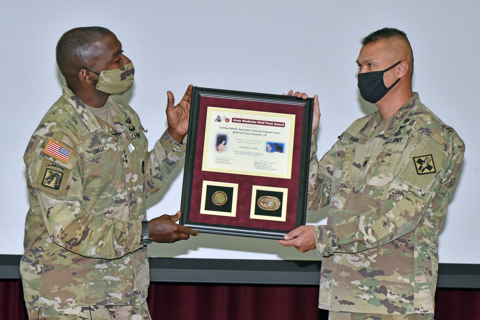 Maj. Johnny Paul (right), Combat Medic Specialist Training Program Department chair, accepts the Army Medicine Wolf Pack Award from Lt. Gen. R. Scott Dingle, Surgeon General of the U.S. Army and Commanding General, U.S. Army Medical Command.