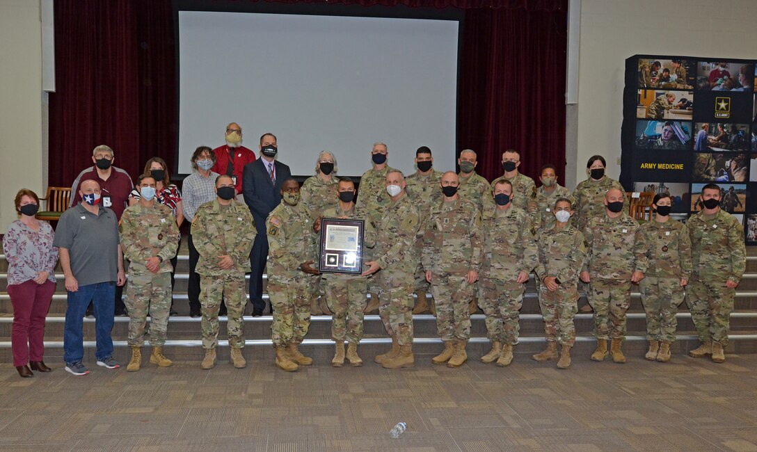 Lt. Gen. R. Scott Dingle, Surgeon General of the U.S. Army and commanding general, U.S. Army Medical Command; Maj. Johnny Paul, Department Chair, Combat Medic Specialist Training Program; and Maj. Gen. Dennis P. LeMaster, U.S. Army Medical Center of Excellence commander; pose for a group photo during the Third Quarter Fiscal Year 2020 Army Medicine Wolf Pack Award ceremony Nov. 9 at the Blesse Auditorium at Joint Base San Antonio-Fort Sam Houston.