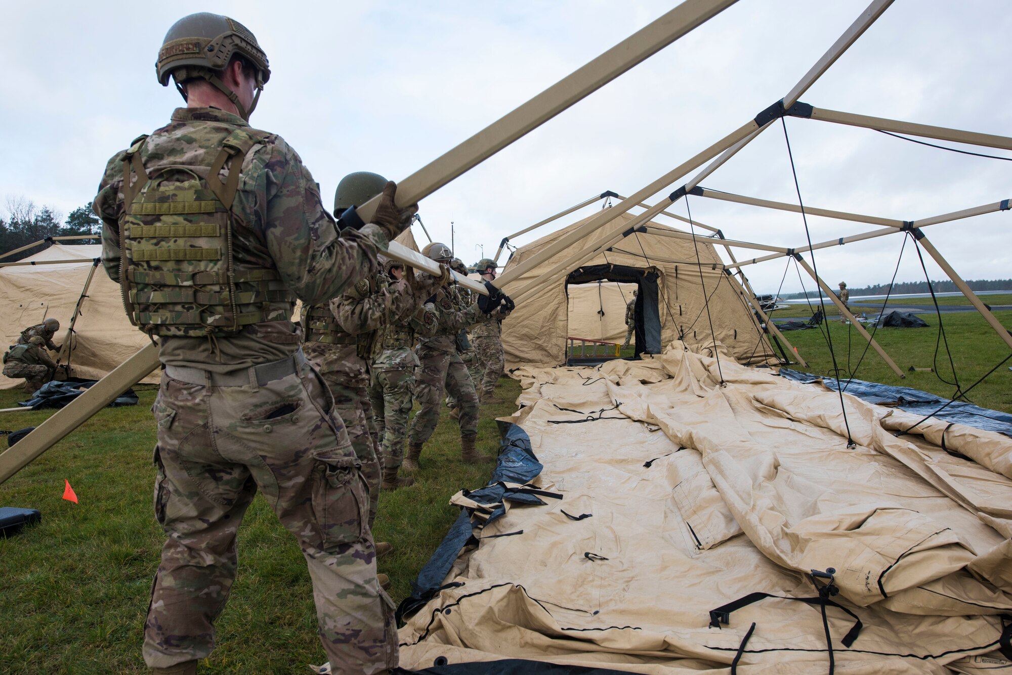 U.S. Airmen assigned to the 435th Contingency Response Group assemble the frame of an expeditionary tent during exercise Agile Wolf 21-01