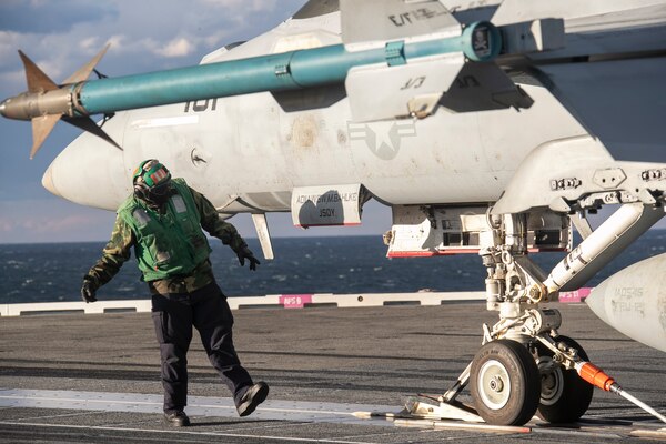 A Sailor conducts a safety check on an F/A-18F Super Hornet attached to the "Jolly Rogers" of Strike Fighter Squadron (VFA) 103 during cyclic flight operations, Nov. 17, 2020.