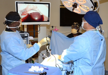 (Front, left to right) Petty Officer 1st Class Wesley Middleton and Petty Officer 2nd Class Domenick Llanda, instructors in the Medical Education and Training Campus Surgical Technologist program, conduct a mock laparoscopic procedure while Petty Officer 1st Class Forest Stewart (center), also an instructor, assists the team. Army, Navy and Air Force ST students are becoming familiar with laparoscopic and laparotomy procedures, which are more universally practiced in the surgical field, after curriculum update to move the training forward.