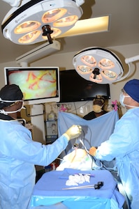 (Front, left to right) Petty Officer 1st Class Wesley Middleton and Petty Officer 2nd Class Domenick Llanda, instructors in the Medical Education and Training Campus Surgical Technologist program, conduct a mock laparoscopic procedure while Petty Officer 1st Class Forest Stewart (center), also an instructor, assists the team. Army, Navy and Air Force ST students are becoming familiar with laparoscopic and laparotomy procedures, which are more universally practiced in the surgical field, after a new curriculum update to move the training forward.