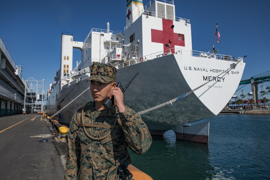 U.S. Marine Corps Pfc. Arnoldo RomeroVelazco, a rifleman with 1st  Battalion, 4th Marine Regiment, 1st Marine Division, posts security to secure the Military Sealift Command hospital ship USNS Mercy (T-AH 19) in Los Angeles, California, March 27.
