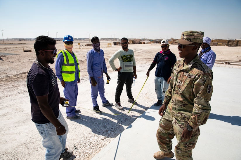 Army Sgt. Zjana Ray, from the 310th Construction Management Team based in Bullville, New York, recieves an update on site progress on November 5, 2020, Al Udeid Airbase, Qatar. Ray's job in theater as a member of Force Protection includes vetting contractors and ensuring a safe work environment as the Army works to complete the Middle East Consolidation project.( Photo by U.S. Army Reserve Sgt. Jermaine Jackson)