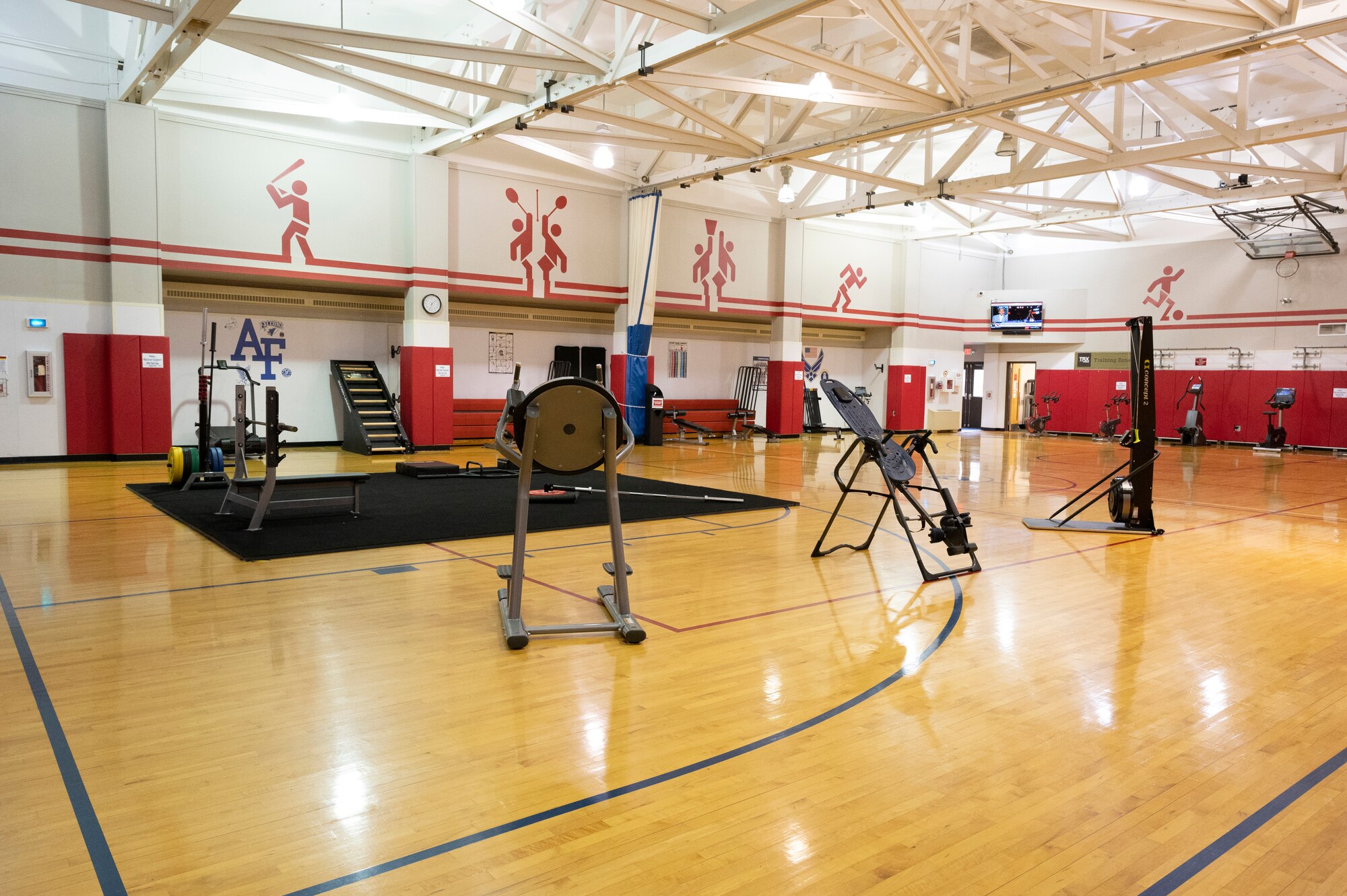 Various workout equipment is staged around an indoor basketball court.