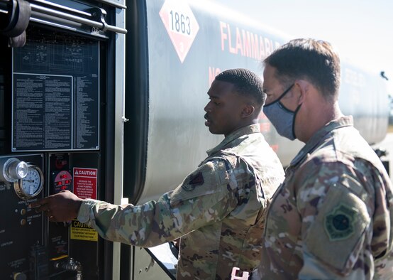 U.S. Air Force Senior Airman shows U.S. Air Force Colonel gauges on the side of a R-11 fuel truck.