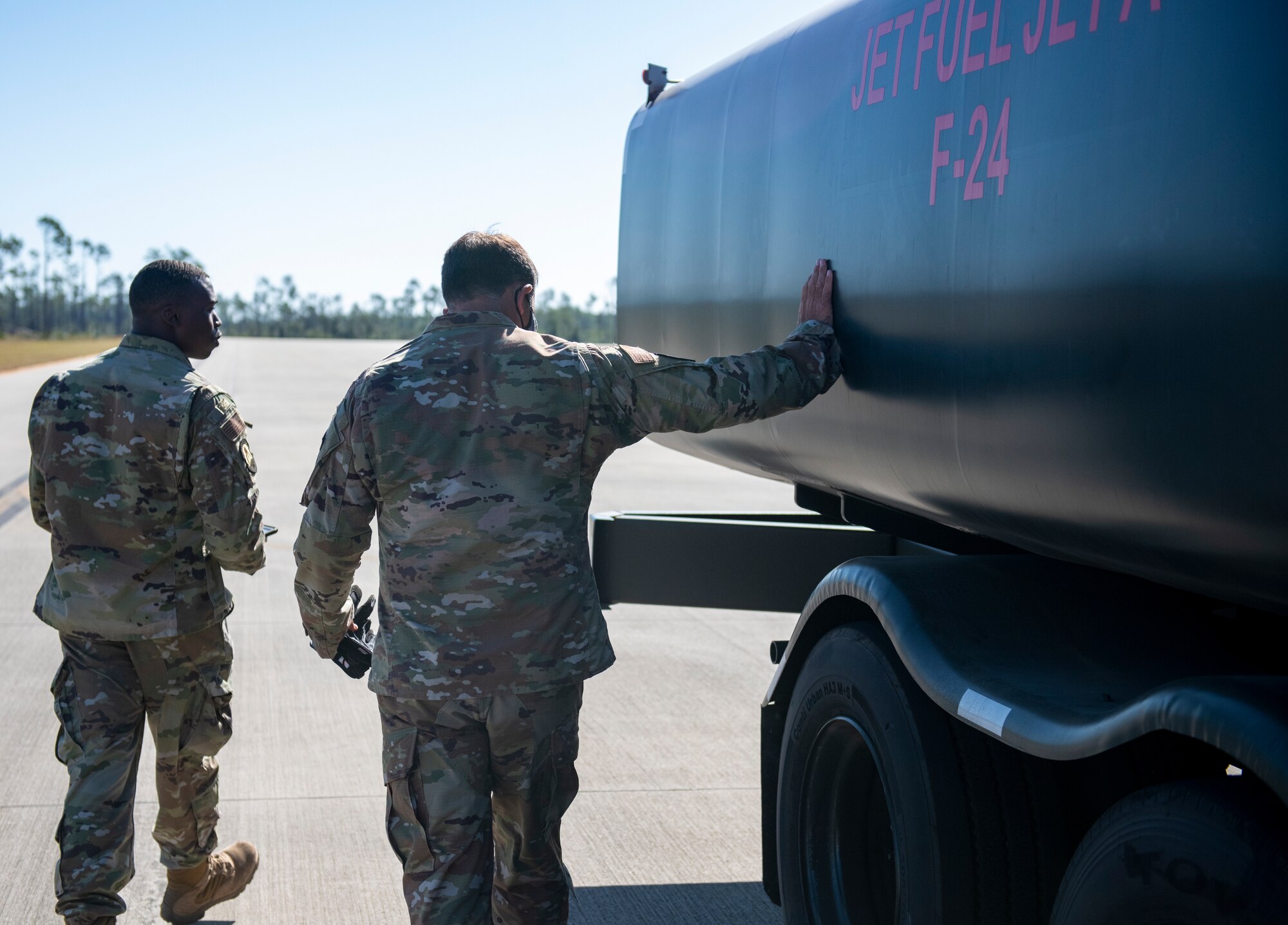 U.S. Air Force Airmen walk around and inspect R-11 fuel truck after refueling an aircraft.