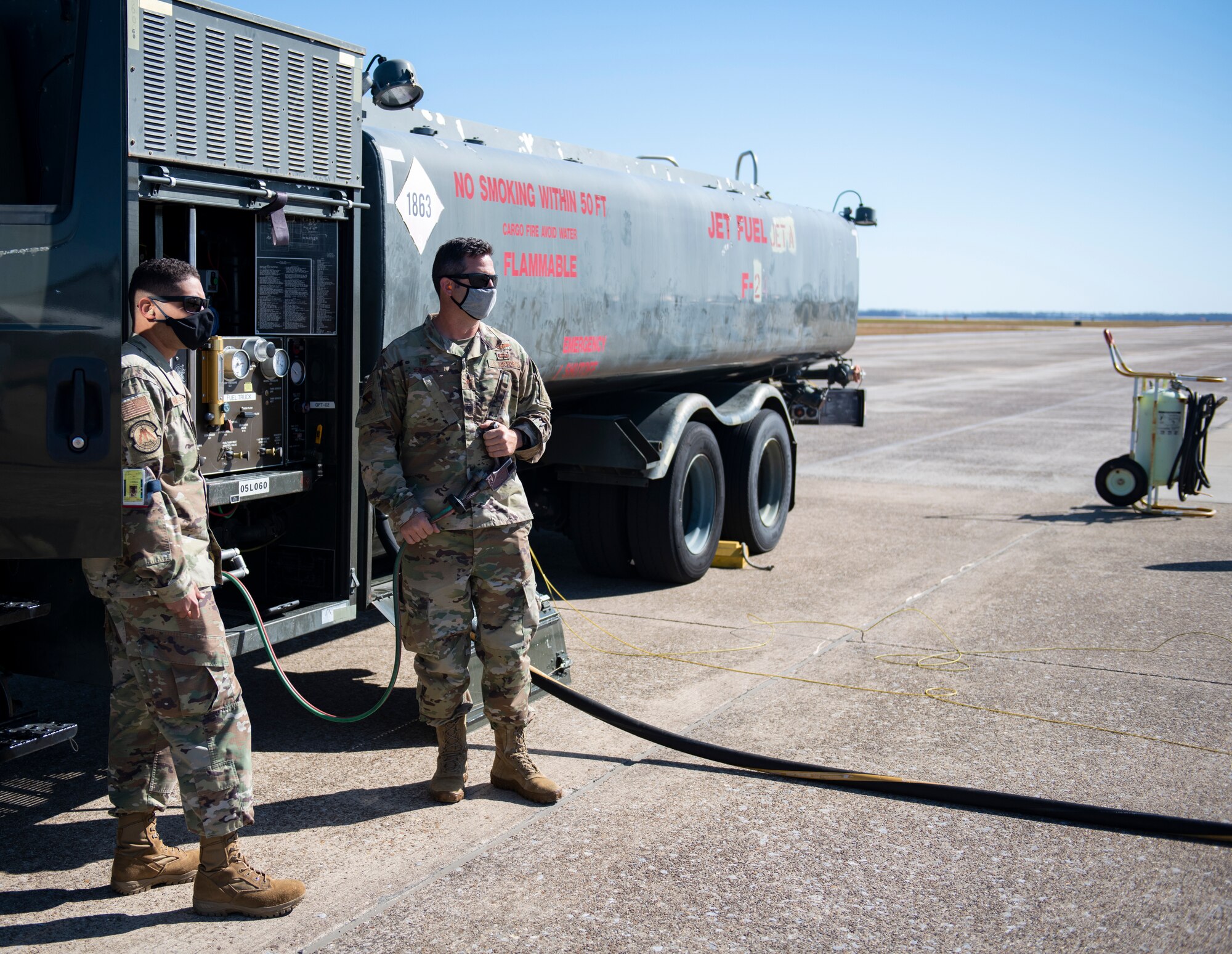 U.S. Air Force Airmen stand next to R-11 fuel truck during refueling of a MU-2 aircraft.