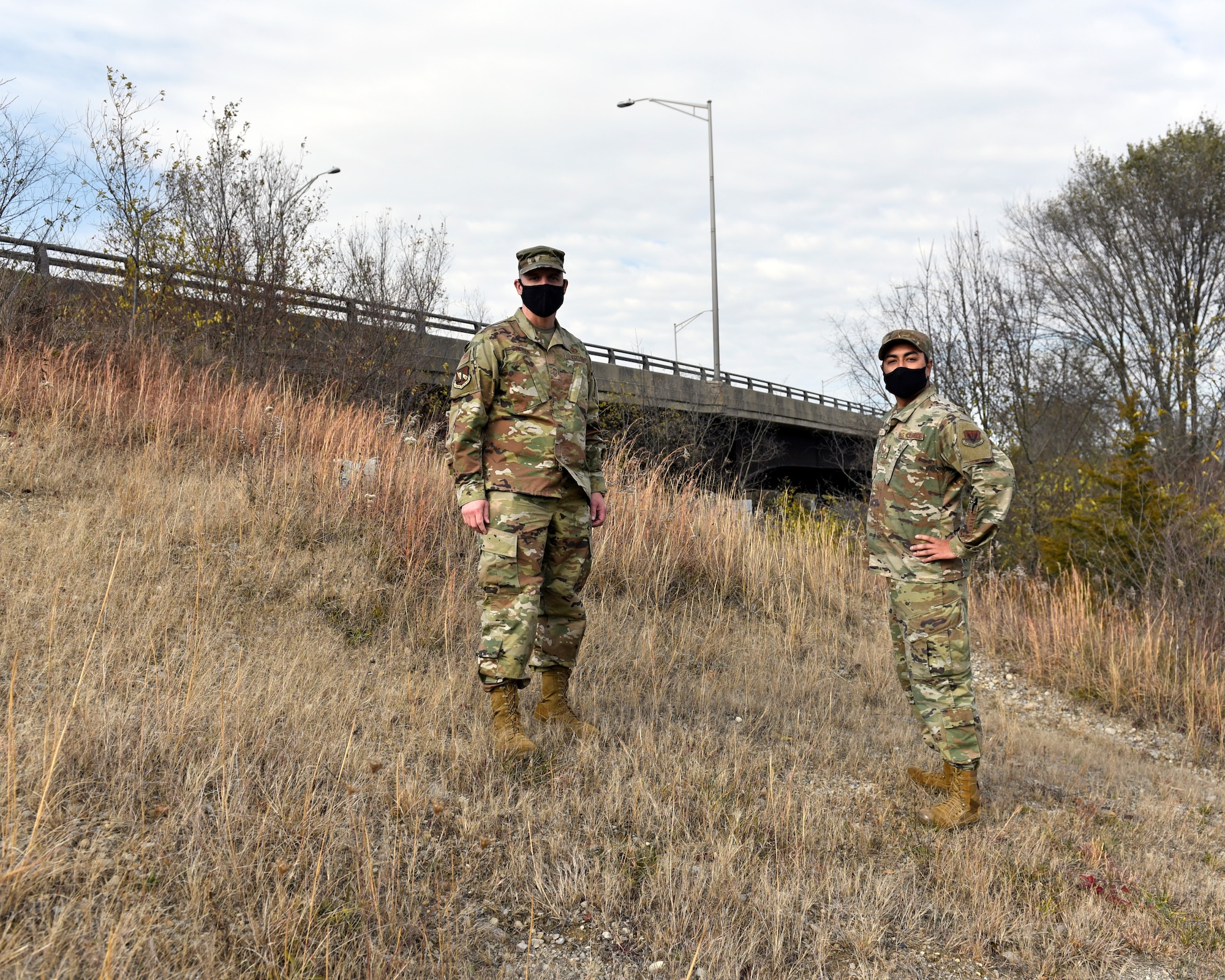 U.S. Air Force Senior Master Sgt. David Briden, left, Air Force Installation Contracting Center expeditionary operations manager, and Tech. Sgt. Anthony Staton, National Air and Space Intelligence Center, stand on the South Maple Avenue bridge in Fairborn, Ohio, on Nov. 20, 2020. Two days earlier, the Airmen assigned to Wright-Patterson Air Force Base stopped to aid a teen who was hanging over the side of the bridge and appeared to be in distress. They stayed with the teen until police and medics arrived. A portion of the photo has been altered for security reasons. (U.S. Air Force photo by Ty Greenlees)