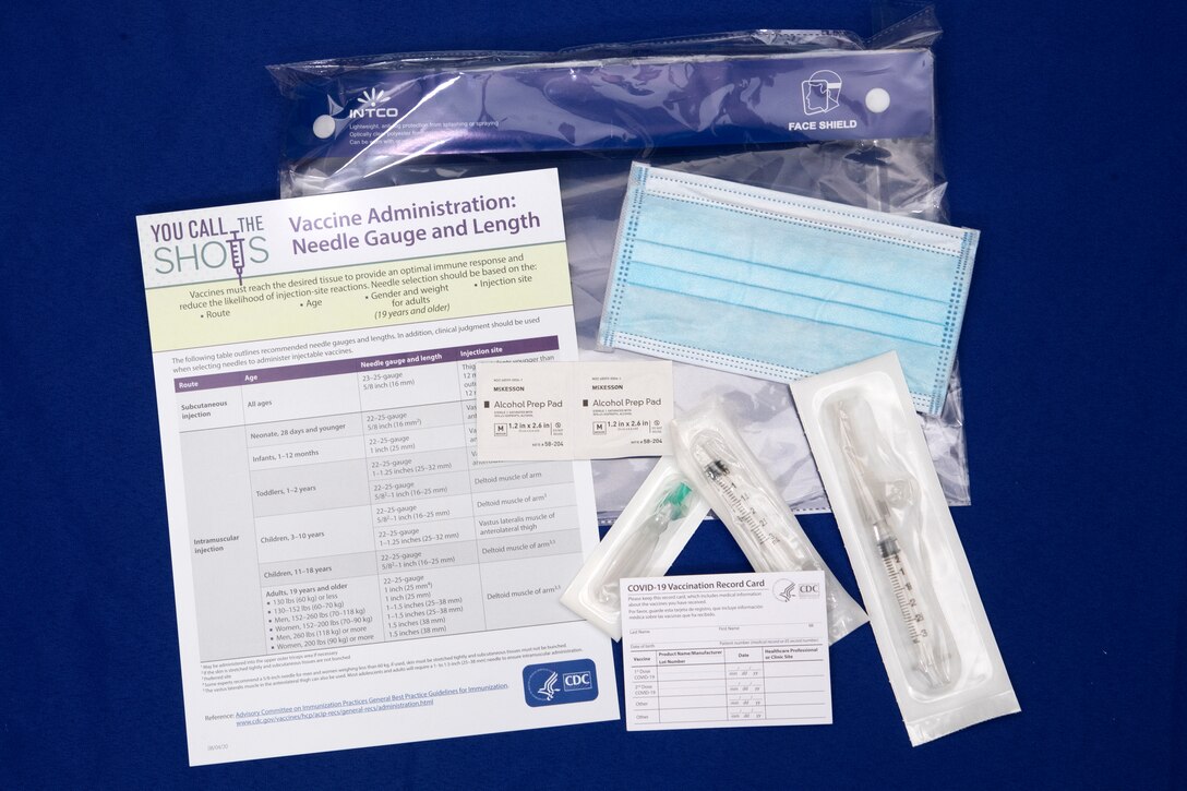 A display of paperwork and COVID-19 prevention items are on a desk.