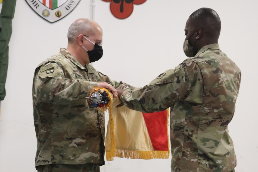 Col. Thomas Dennis and Command Sgt. Maj. Jimmie Smith uncase the 143rd Regional Support Group colors after the transfer of authority ceremony for Area Support Group-Jordan. The 143rd RSG mobilized to Jordan this month to provide support operations for U.S. forces in Jordan. The U.S. military is in Jordan to partner with the Jordan Armed Forces to meet common security objectives in the region.