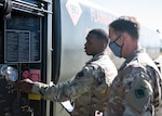 U.S. Air Force Senior Airman shows U.S. Air Force Colonel gauges on the side of a R-11 fuel truck.