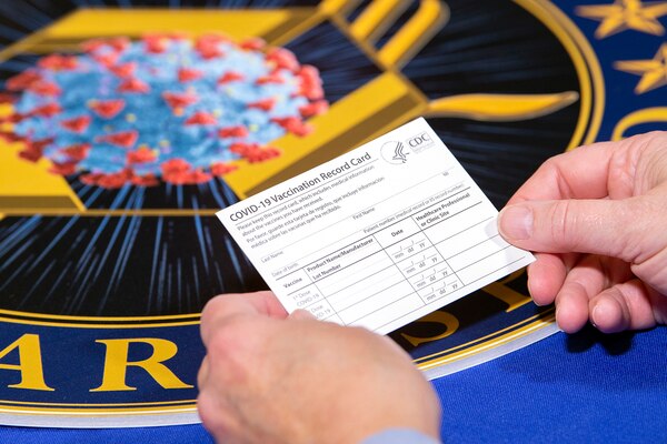 A person holds a vaccine record card.