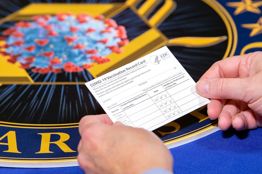 A person holds a vaccine record card.