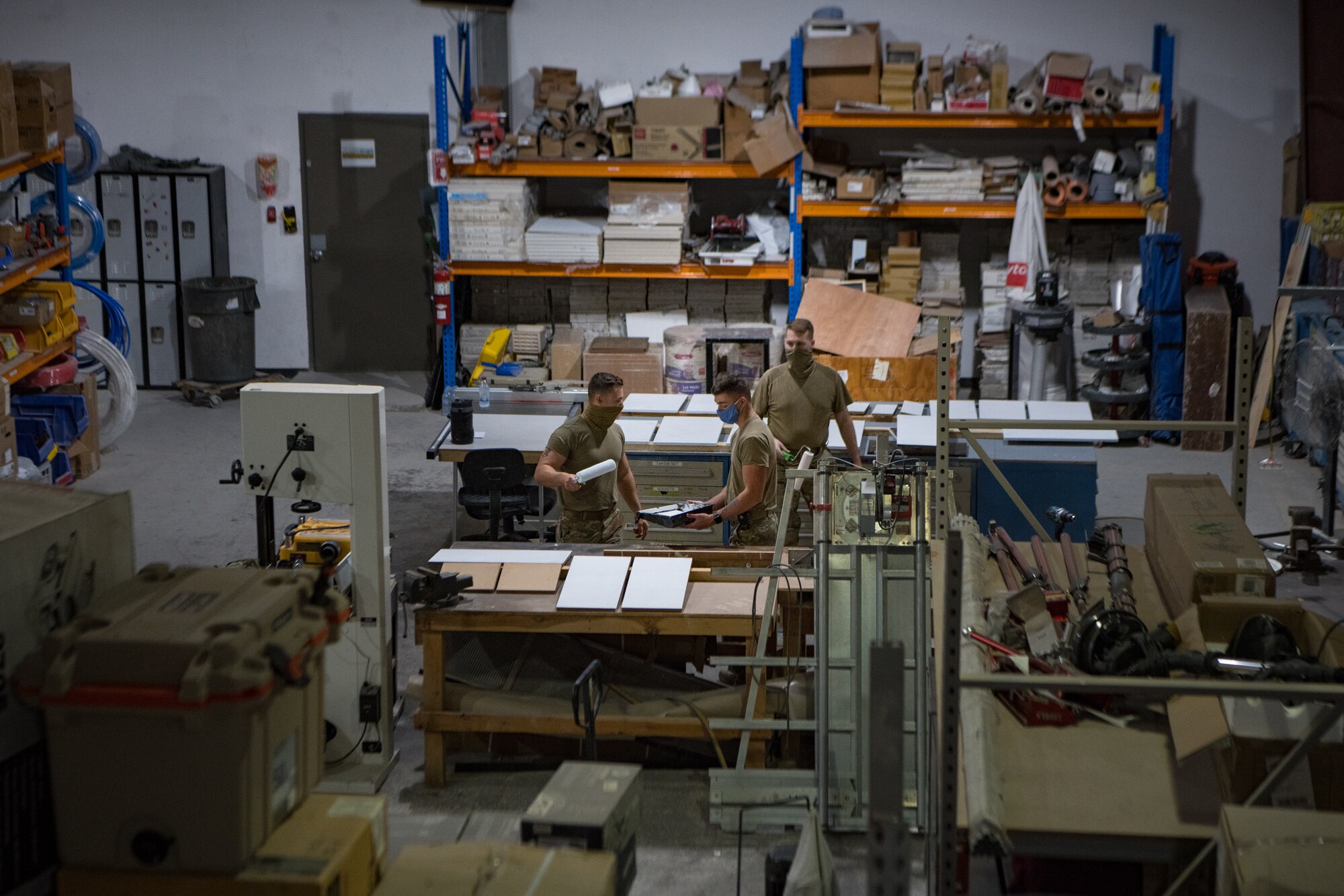Three structural specialists with the 379th Expeditionary Civil Engineering Squadron paint disassembled cabinet doors Nov. 3, 2020, at Al Udeid Air Base, Qatar. The 379th ECES facility management team has been tasked to address minor maintenance issues in every dorm building on base, improving the quality of life for service members stationed at AUAB. (U.S. Air National Guard photo by Tech. Sgt. Brigette Waltermire)