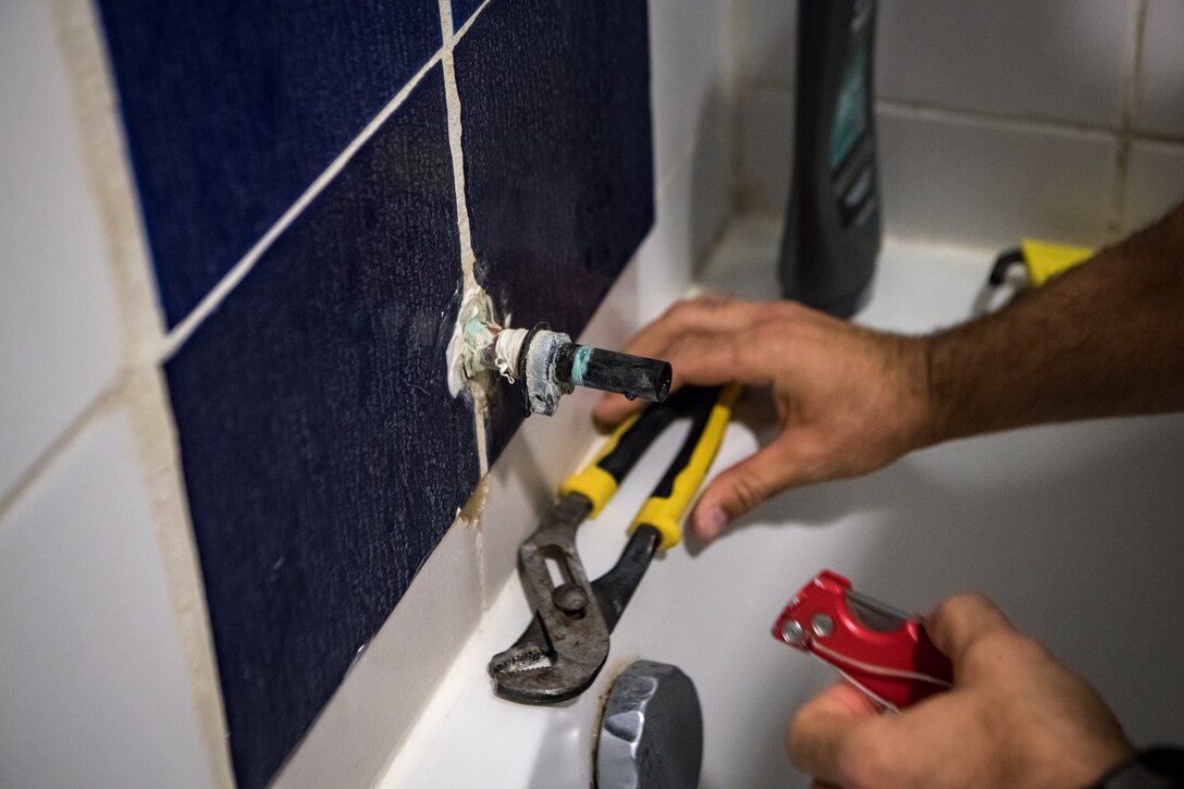 Staff Sgt. Levi Barnett, a water and fuels system maintenance specialist with the 379th Expeditionary Civil Engineer Squadron facility management team, prepares to reinstall a faucet that was leaking in a dorm room Oct. 27, 2020, at Al Udeid Air Base, Qatar. The 379th ECES facility management team has been tasked to address minor maintenance issues in every dorm building on base, improving the quality of life for service members stationed at AUAB. (U.S. Air National Guard photo by Tech. Sgt. Brigette Waltermire)