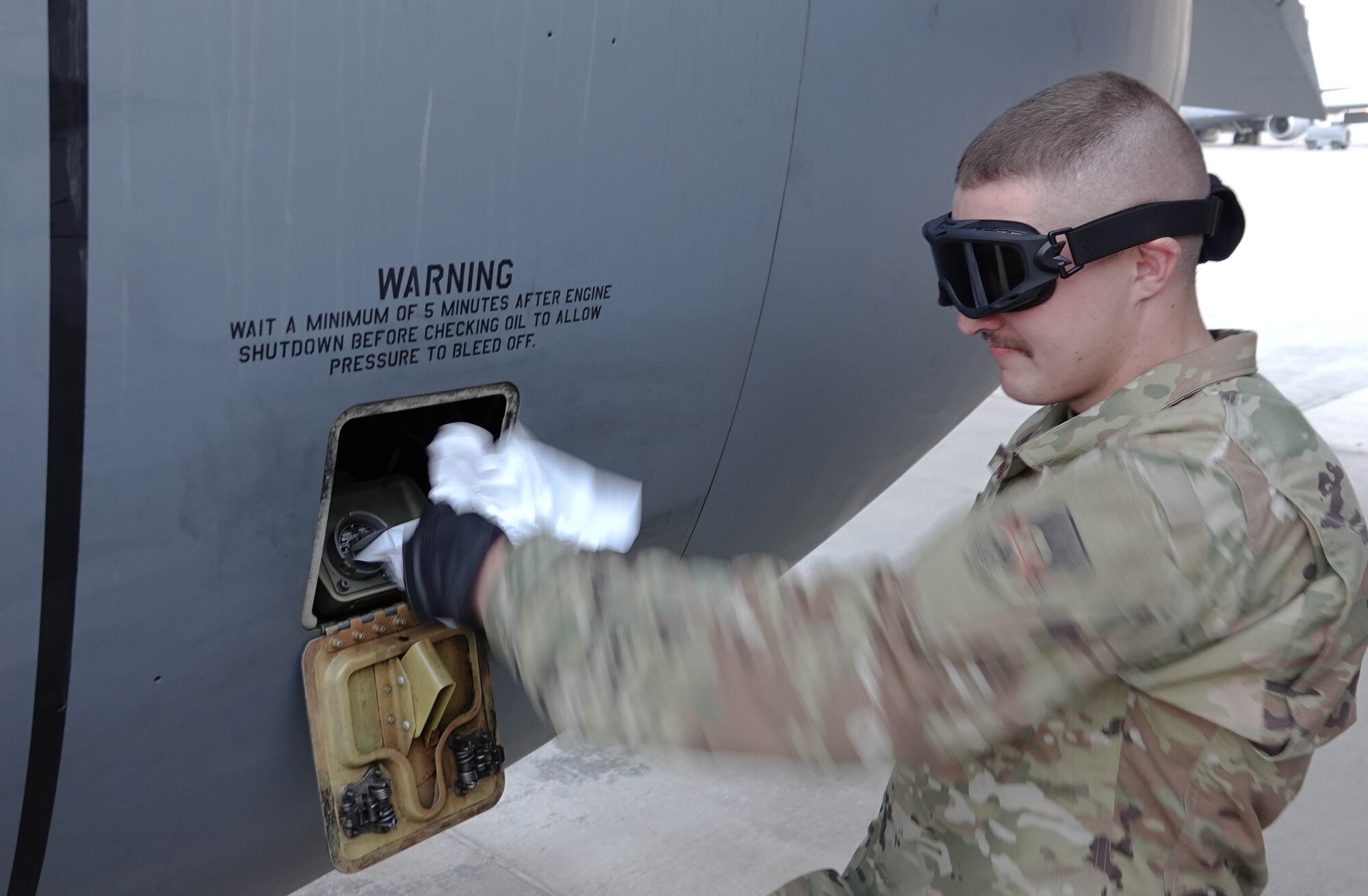 Airman 1st Class Trever Van Oss, with the 379th Expeditionary Logistics Readiness Squadron, services the oil of a KC-135 Stratotanker aircraft during his crew chief for a day event on Nov. 17, 2020, at Al Udeid Air Base, Qatar. Van Oss worked alongside maintainers for a day, learning how to launch a KC-135, calling flight controls and engine start, as well as how to recover it, marshaling it to a parking spot and servicing the engine oil after shut down. The crew chief for a day program provides interested Airmen of any military specialty, direct exposure to the 379th Air Expeditionary Wing's robust aerial refueling capability. (Photo courtesy of the U.S. Air Force)