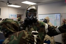 U.S. Air Force Master Sgt. Ian Ouellette, the superintendent for the 628th Air Base Wing Inspector General office, grades Airmen from the Emergency Operations Center (EOC) on how efficiently they equip Mission Oriented Protective Posture gear (MOPP), at McEntire Joint National Guard Base, S.C., Nov. 16, 2020. Palmetto Challenge is a global mobilization exercise held at McEntire Joint National Guard Base, S.C. The exercise is held in order to develop readiness and awareness in a simulated deployed environment for over 100 Airmen from Joint Base Charleston.