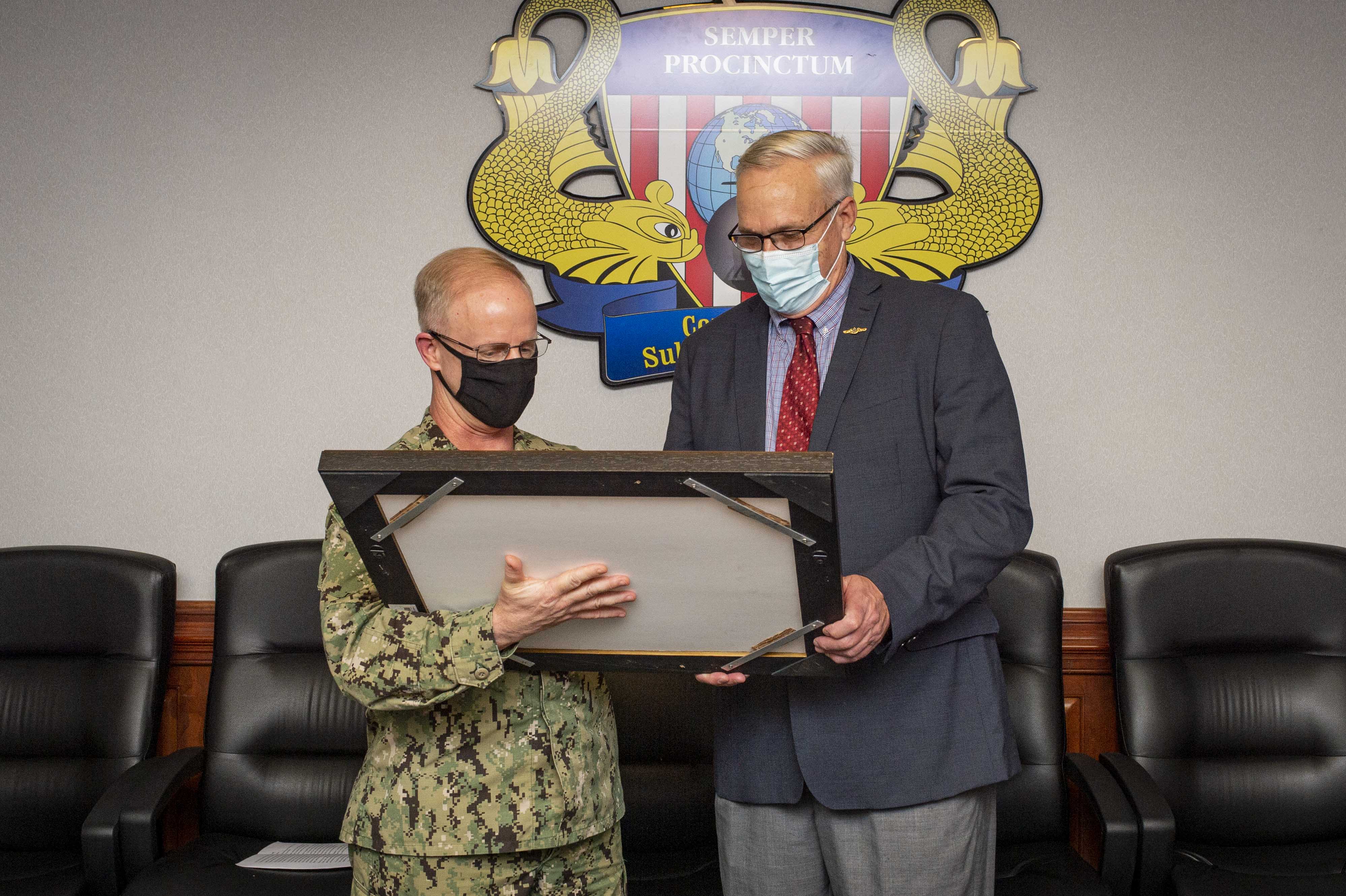 Vice Adm. Daryl Caudle, commander, Submarine Forces, presents a gift to John D. Moss, former director, submarine requirements and warfare development, during a retirement ceremony at Commander, Submarine Force Atlantic, Nov. 13, 2020.