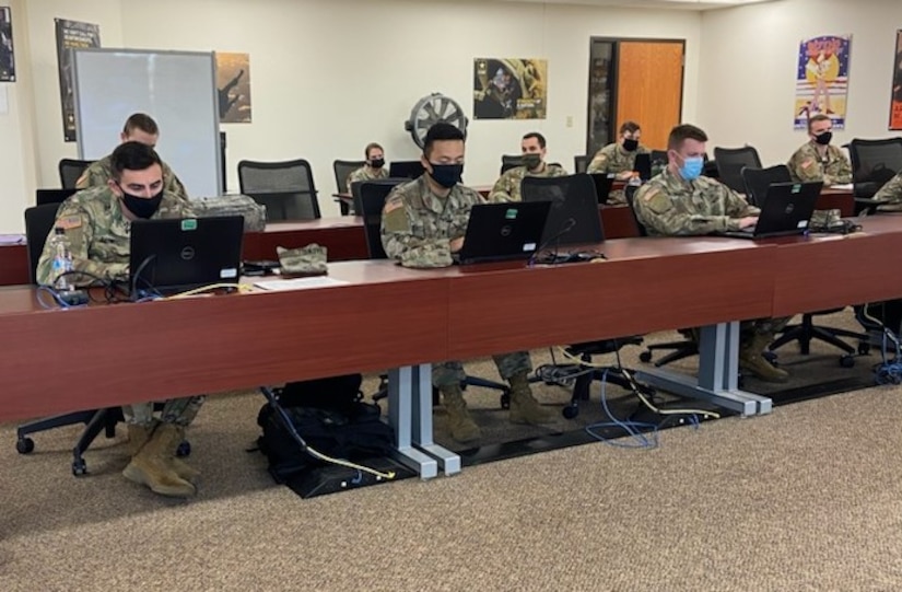 soldiers in uniform sitting at computer terminals