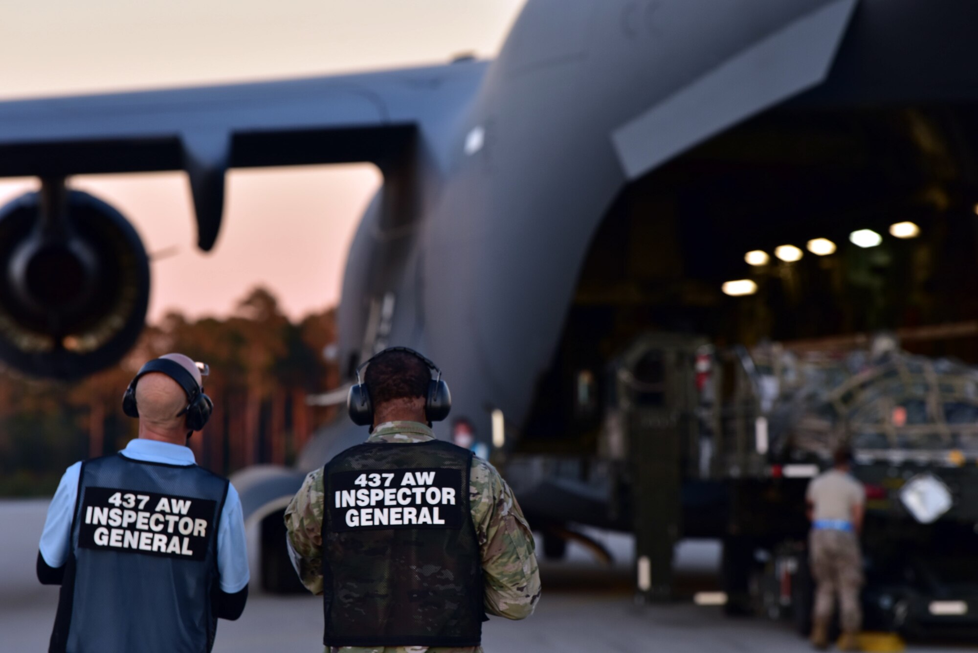 U.S. Air Force Master Sgt. Bradley Moorer, an Inspector General Wing Inspection Team superintendent for the 437th Airlift Wing (left), and Mark Vickers, the 437th AW IG director of inspections (right), watch as a C-17 Globemaster III containing Airmen and supplies lands, at McEntire Joint National Guard Base, S.C., Nov. 16, 2020. Palmetto Challenge is a global mobilization exercise held at McEntire Joint National Guard Base, S.C., and Pope Army Airfield, N.C. The exercise is held in order to develop readiness and awareness in a simulated deployed environment for over 100 Airmen from Joint Base Charleston.