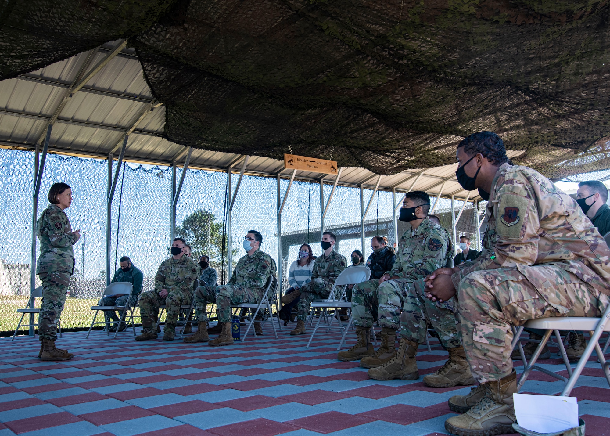 A photo of Airmen listening to a speaker.