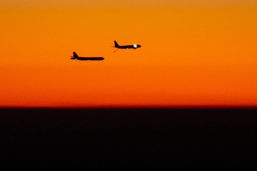 Two aircraft fly next to each other.