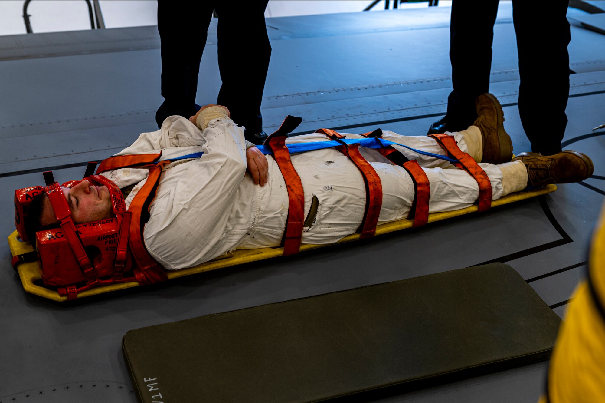 Firefighters from the Allegheny County Fire Rescue inspect the straps on a stretcher Staff Sgt. Cory Burtom 911th Maintenance Squadron aircraft hydraulic systems maintainer is attached at the Pittsburgh International Airport Air Reserve Station, Pennsylvania, Nov. 3, 2020.