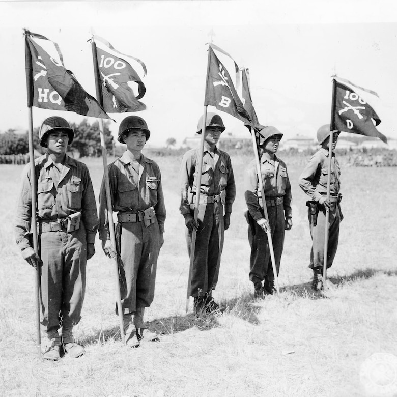 Five men stand at attention while holding flags.