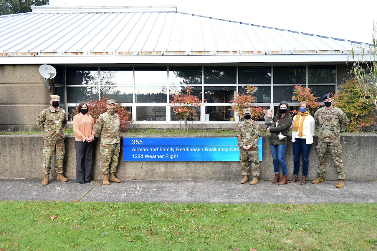 Service members and loved ones pose in front of a readiness center.
