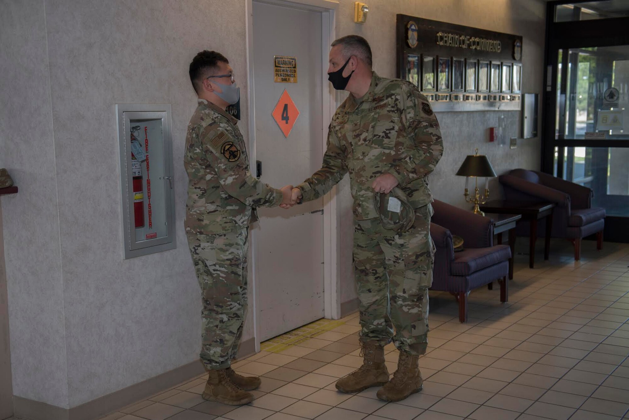 U.S. Air Force Col. Corey Simmons, right, 60th Air Mobility Wing commander, recognizes Senior Airman Jihoon Lee, 60th Operations Support Squadron air traffic controller, as a star performer during Leadership Rounds Nov. 20, 2020, at Travis Air Force Base, California. The Leadership Rounds program provides 60th AMW leadership an opportunity to interact with Airmen and receive a detailed view of each mission performed at Travis AFB. (U.S. Air Force photo by Senior Airman Cameron Otte)