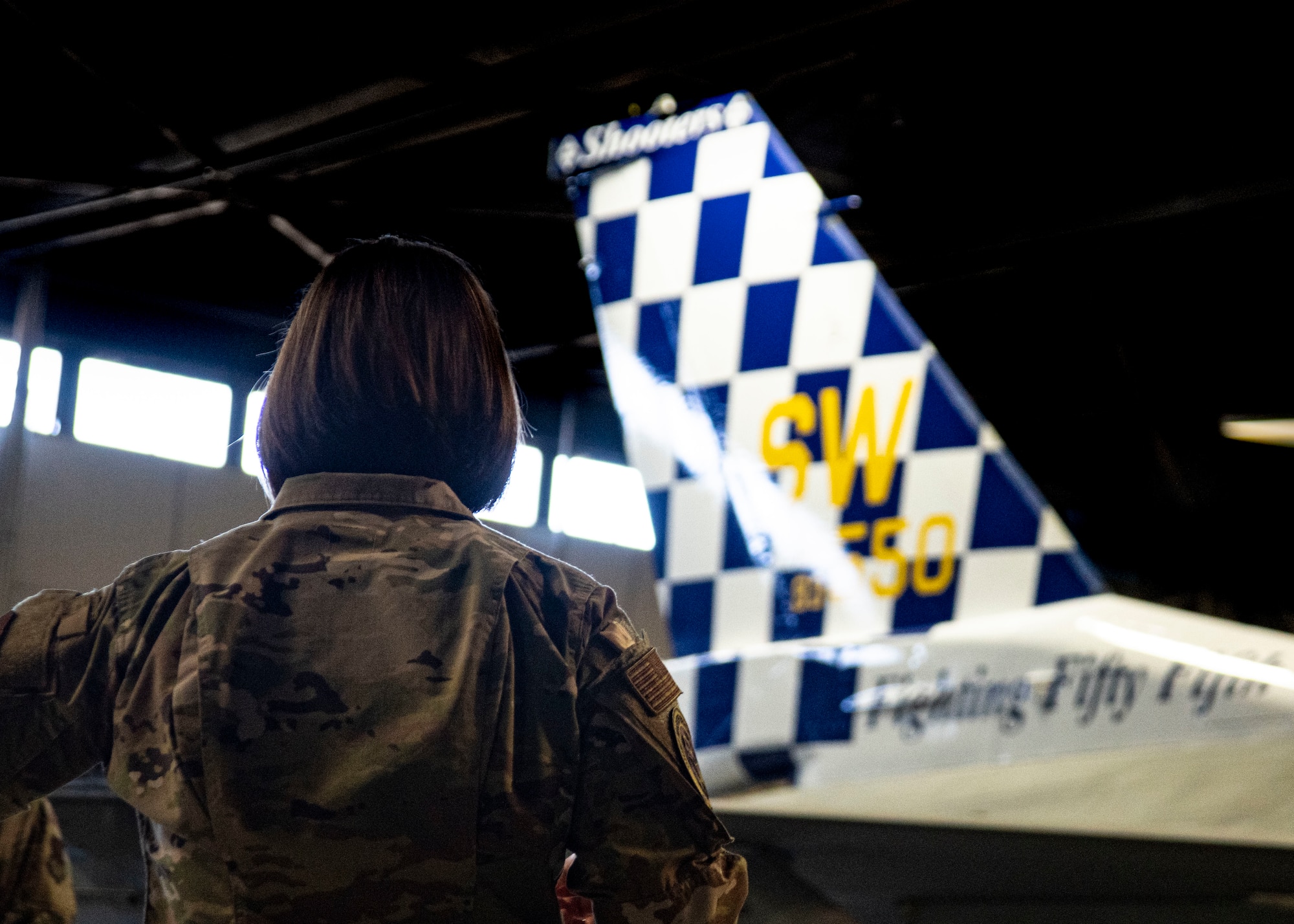A photo of an Airman standing with a tail flash.