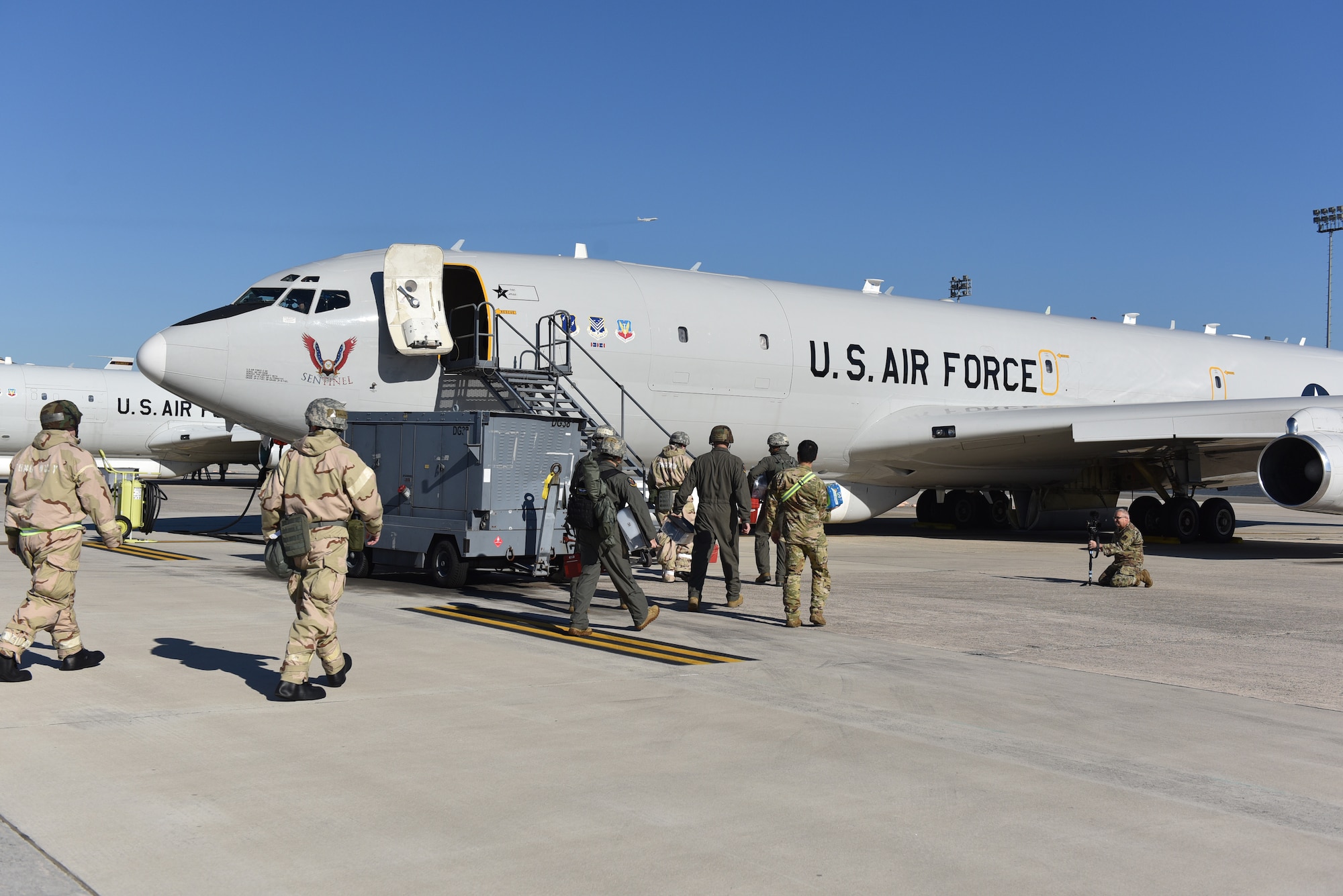 Photo shows Airmen walking up stairs into an aircraft.