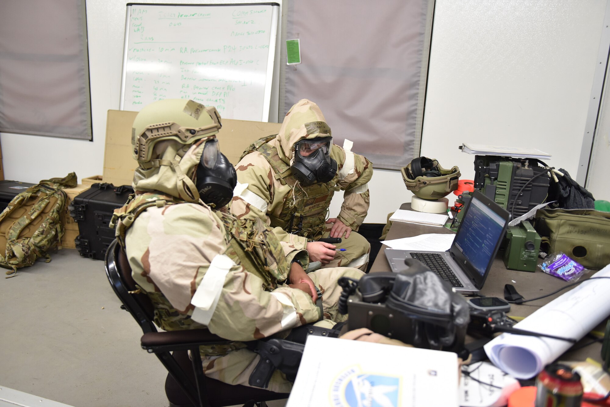 Photo shows two Airmen logging into a laptop.