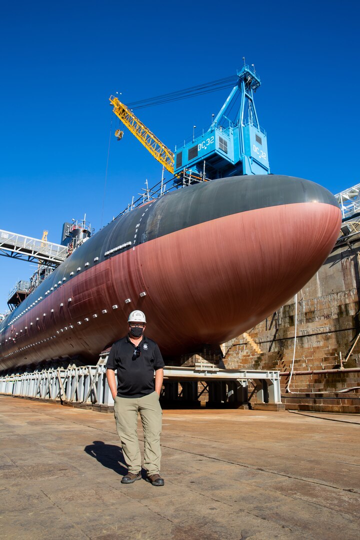 Safety Department (Code 106) Moored Training Ships Project Safety Manager Jon Larrew in front of the USS San Francisco (SSN 711) undergoing Moored Training Ship Conversion at Norfolk Naval Shipyard.